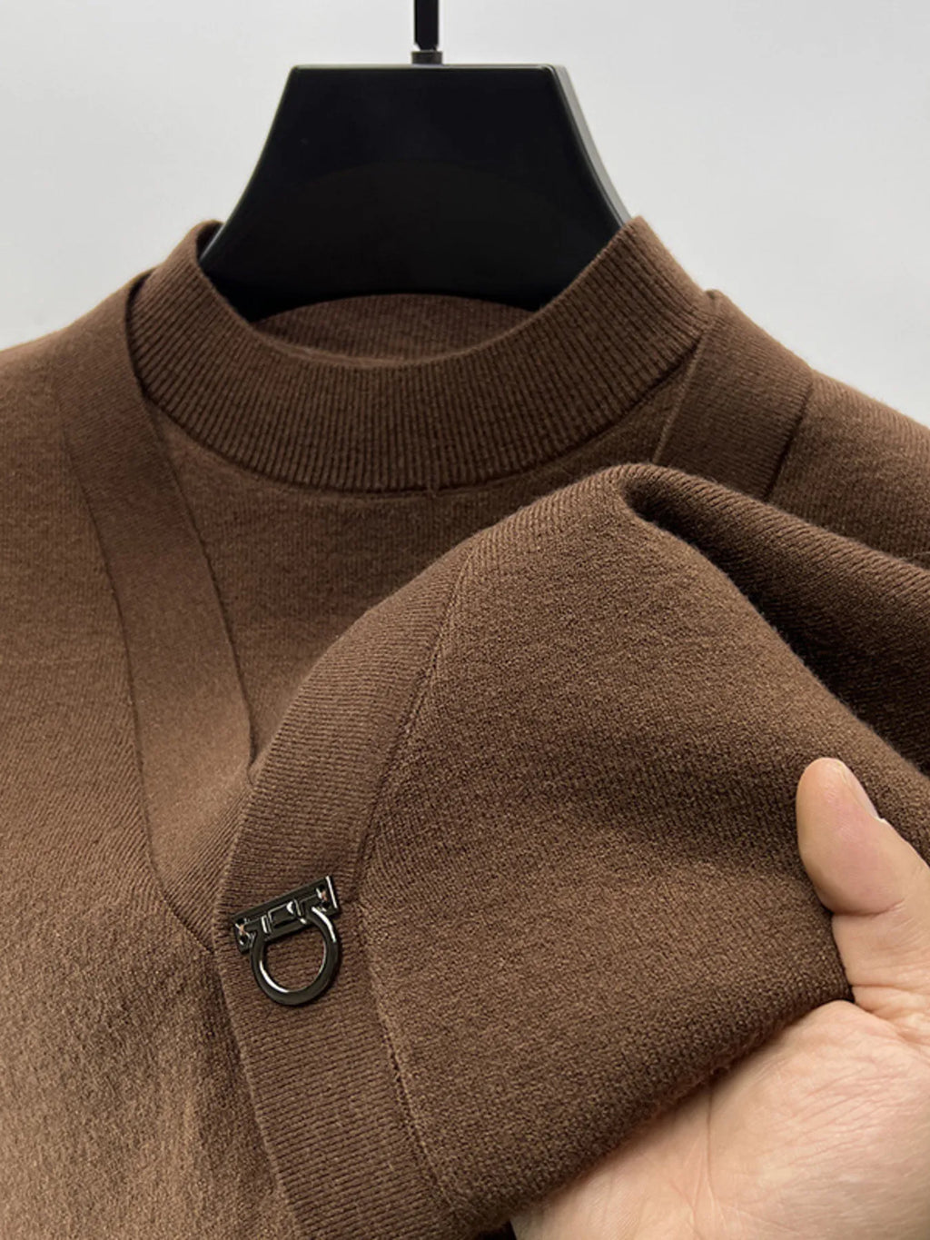 Brown knit sweater close-up: ribbed collar and ring-loop closure at chest