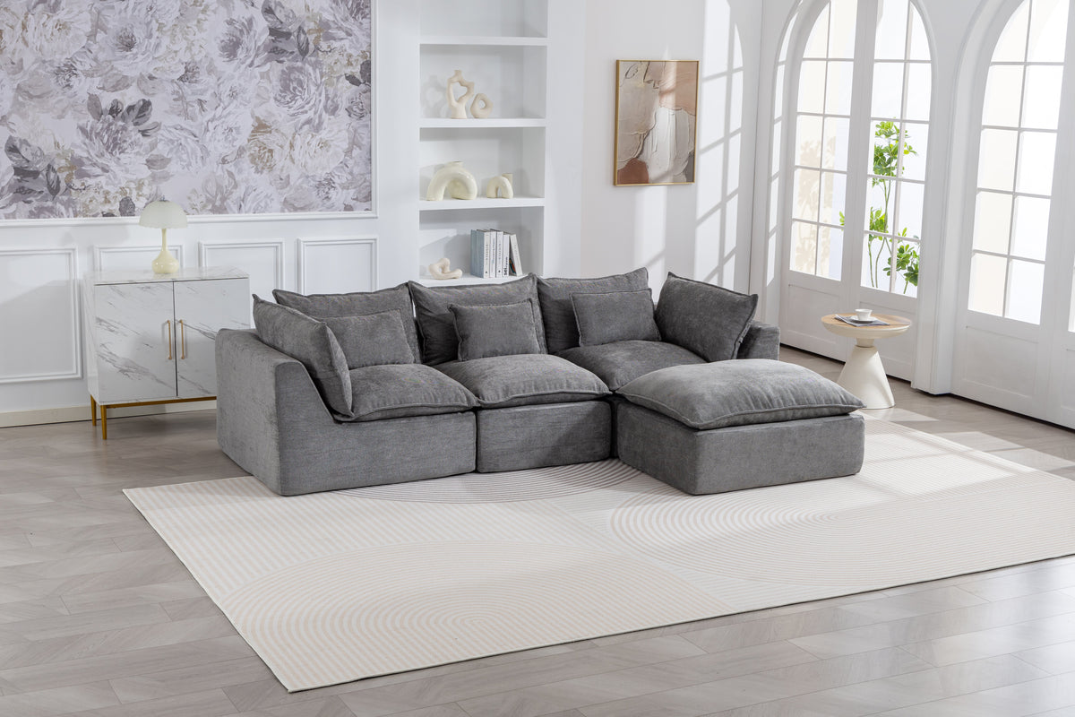 Gray sectional sofa with chaise ottoman and back cushions in a modular configuration