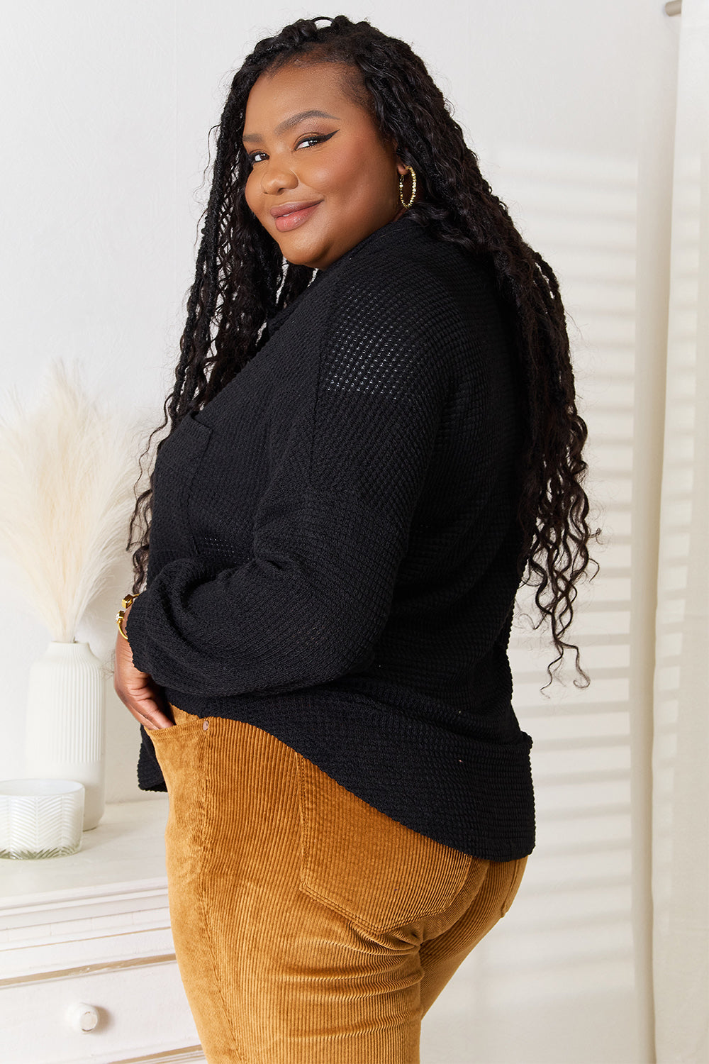 Black waffle-knit collared shirt, side view with button placket and long sleeves