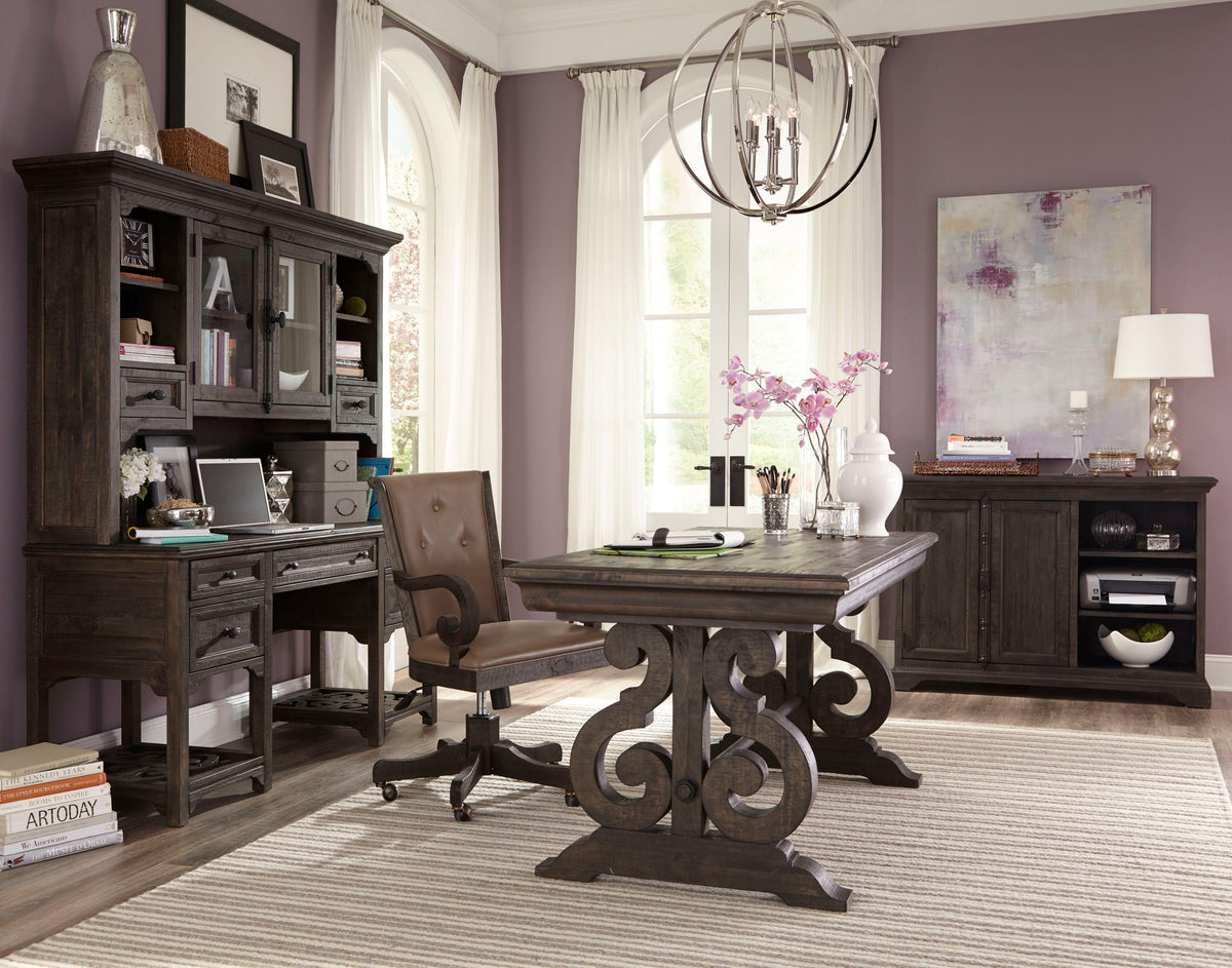 Brown upholstered desk chair with curved arms and tufted back on rolling casters