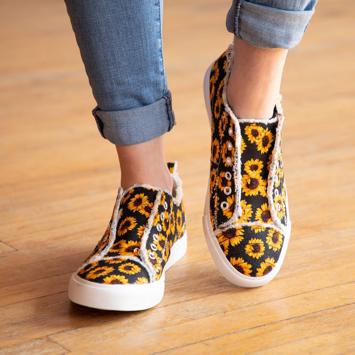 Sunflower print slip-on canvas sneakers on feet with white rubber sole