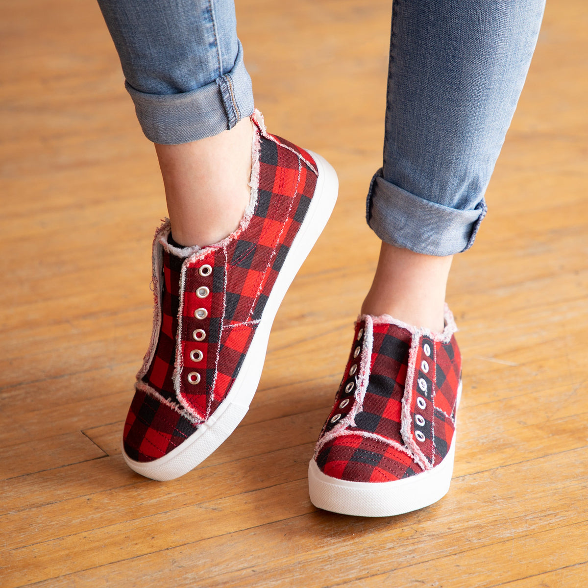 Red-and-black plaid slip-on canvas sneakers with eyelet laces and white rubber sole