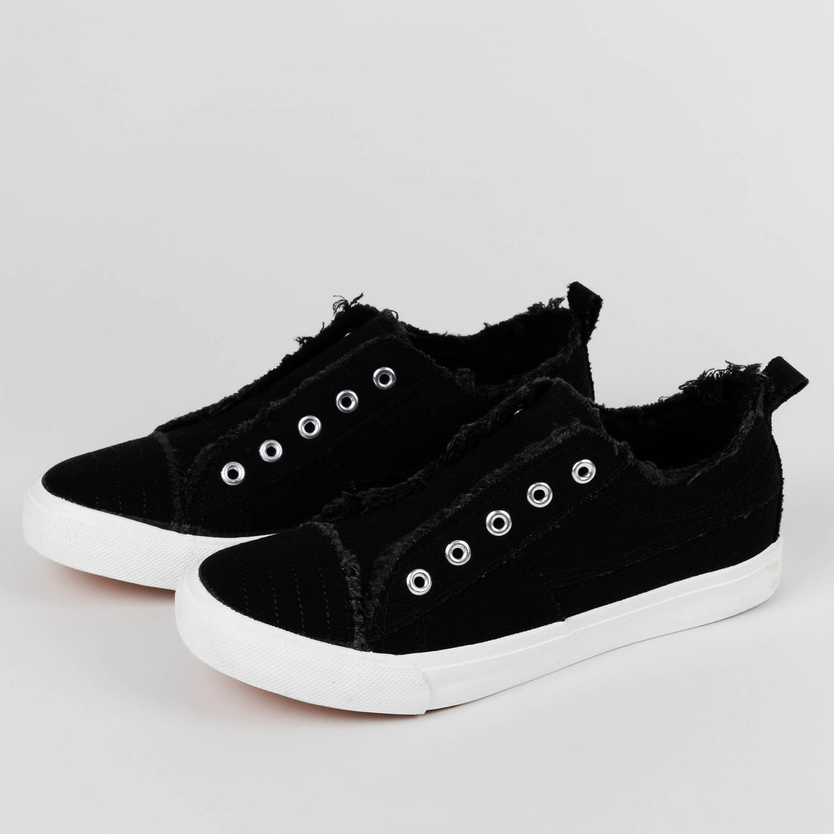 Black slip-on canvas sneakers with fuzzy lining and grommet eyelets