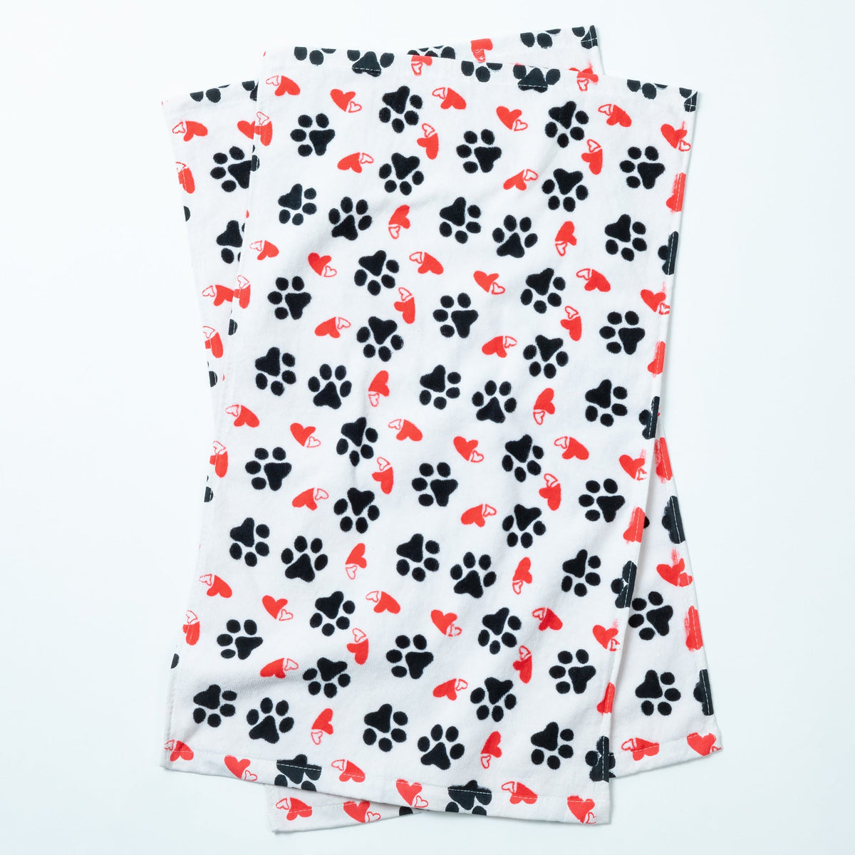 Set of 2 white bath hand towels with black paw prints and red hearts, laid flat
