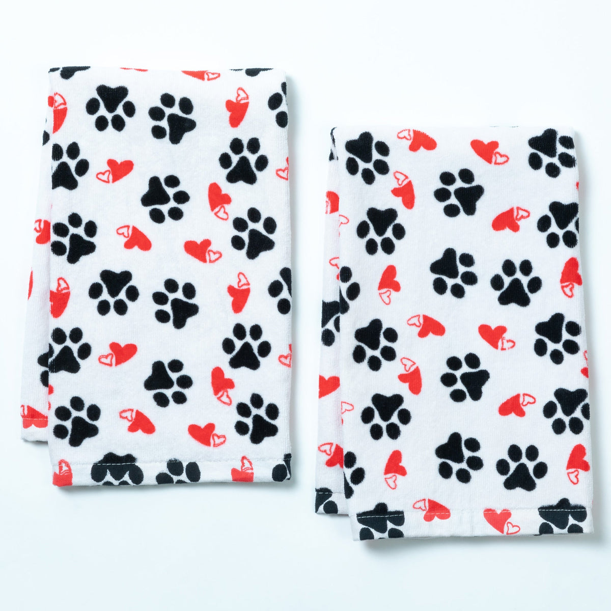Set of 2 white bath hand towels with black paw prints and red hearts, folded