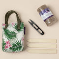 Tropical floral tote bag with green handles, black scissors, bundled seed packets