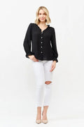 Black polka-dot blouse with ruffle neckline, button front, and long sleeves