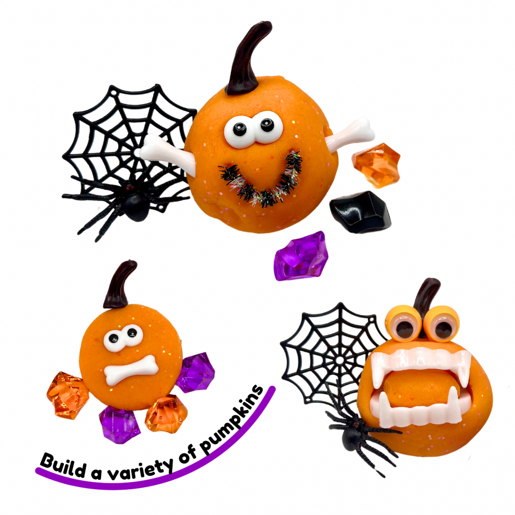 Two orange playdough jars with jack-o'-lantern faces, spider web charms, and purple crystals