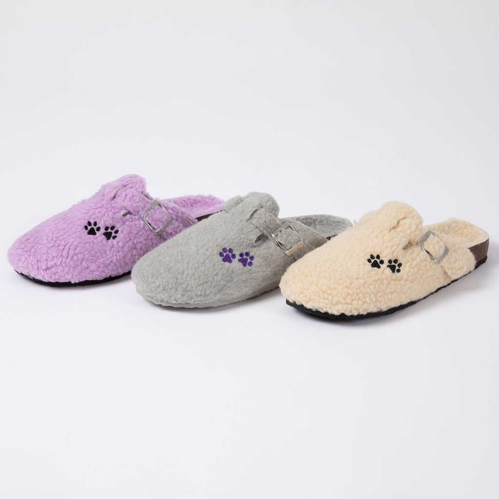 Assorted plush sherpa clog slippers: purple, gray, and cream with paw-print appliques