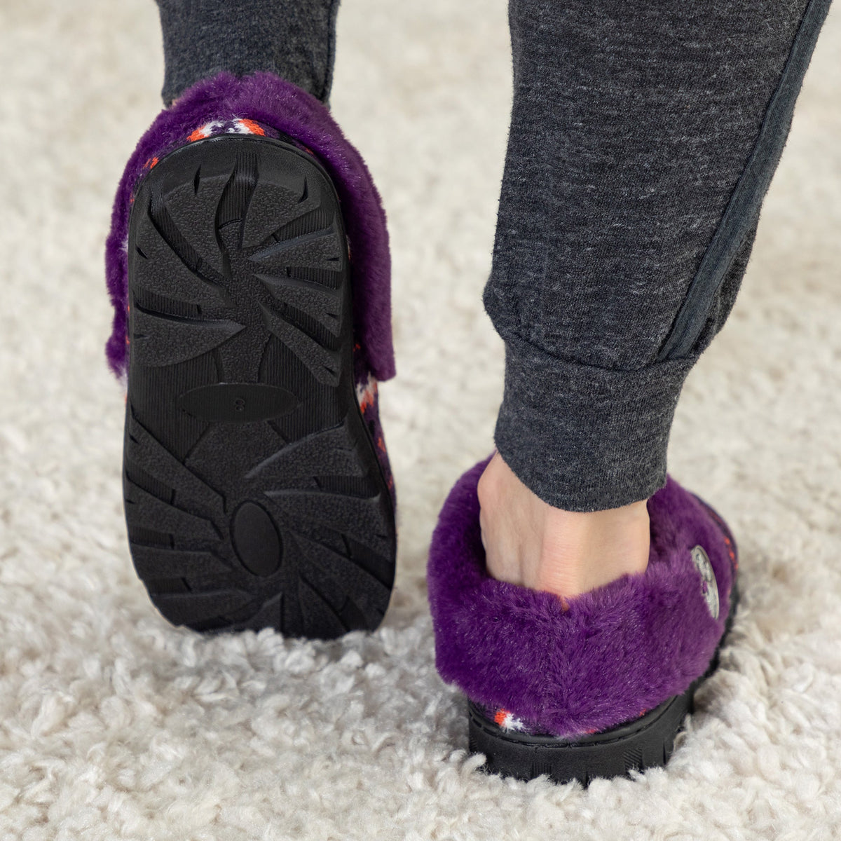 Purple knit clog slippers shown from below with textured dark rubber outsole