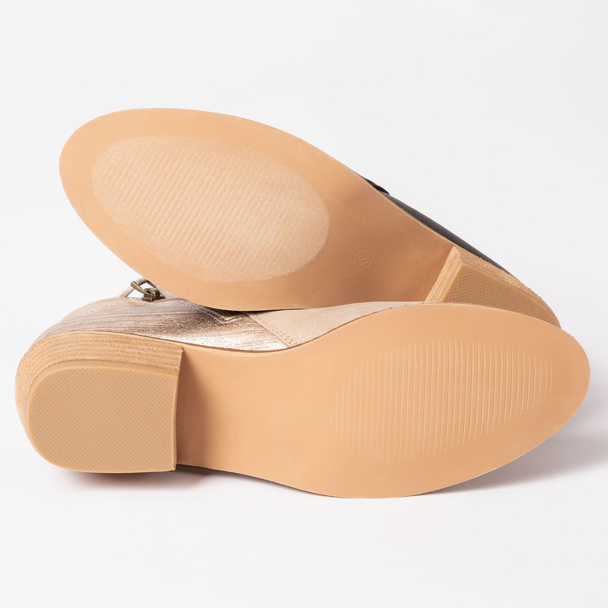Tan ankle boot outsole view with tread and side-zip hardware.
