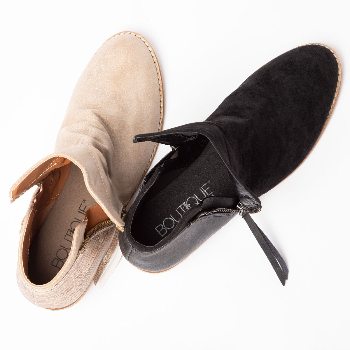 Ankle boots close-up: tan and black suede-like uppers, side zipper and tie pulls.