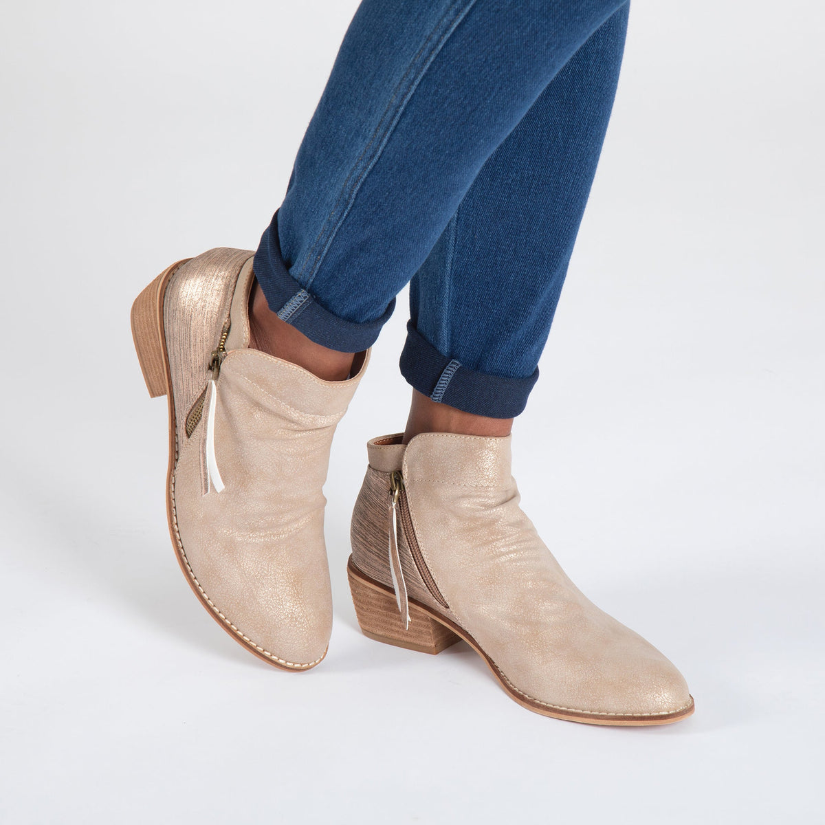 Tan side-zip ankle boots on model with blue jeans, low block heel and tie pull.