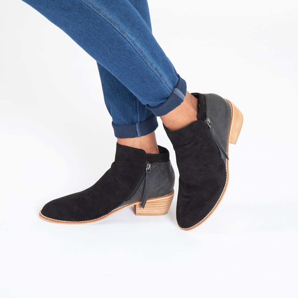 Black side-zip ankle boots on model with blue jeans, low block heel and tie pull.