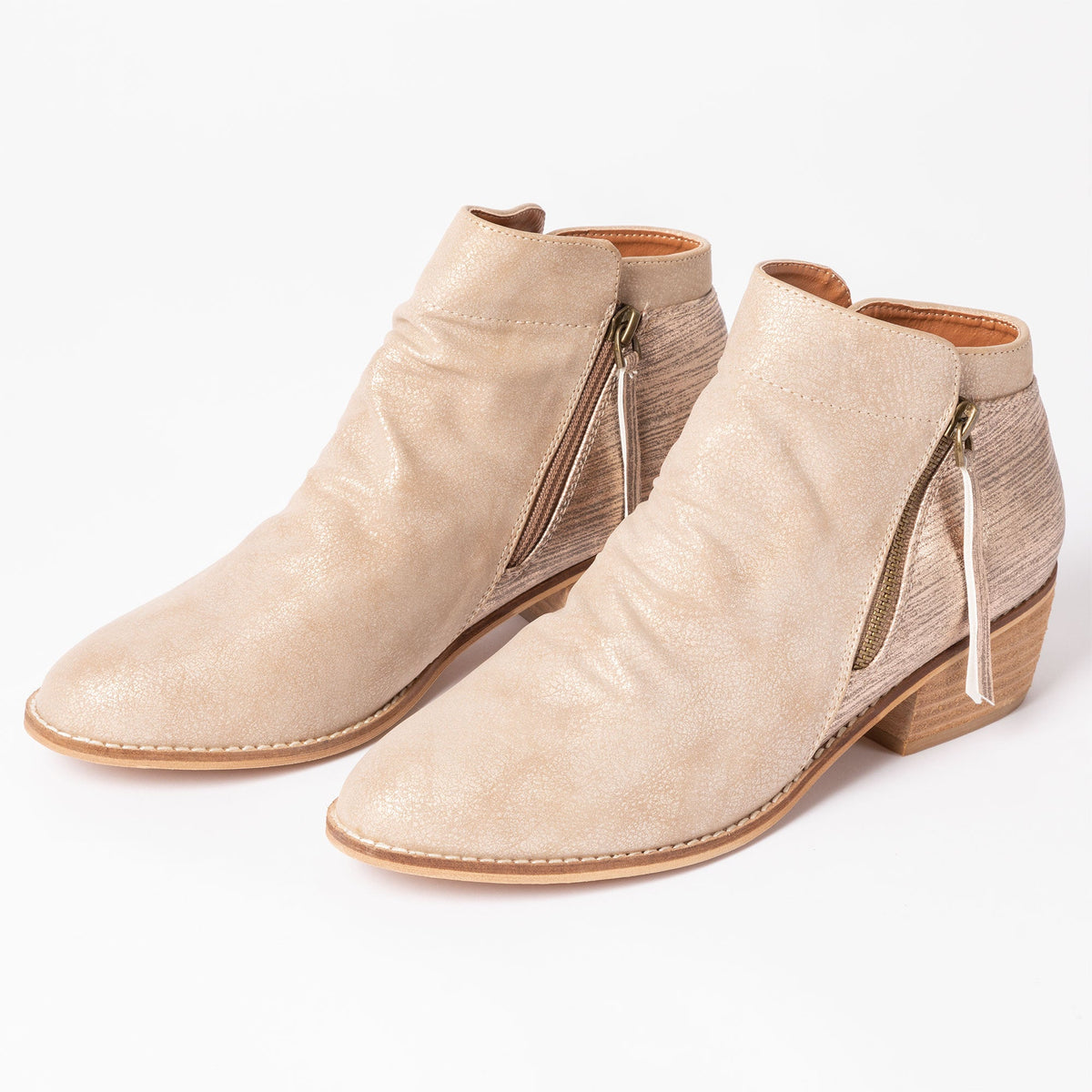 Tan side-zip ankle boots with tassel pull, stitched seams, and low block heel.