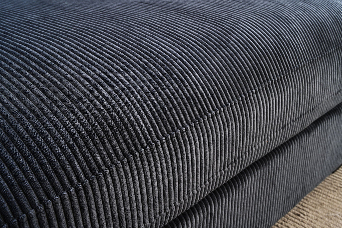 L-shaped sectional sofa with chaise fabric detail, dark textured upholstery close-up