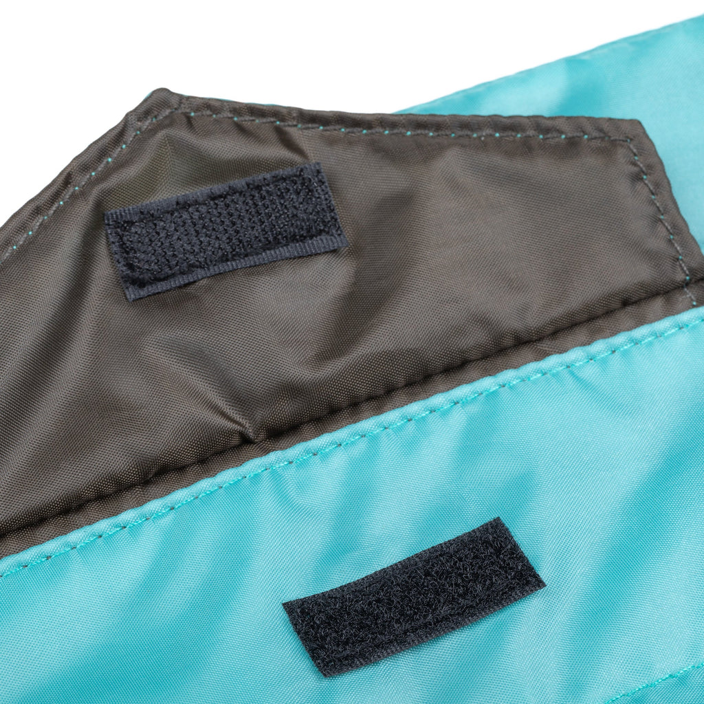 Blue puffer tablet case with dark fabric patch tabs and stitched edge detail