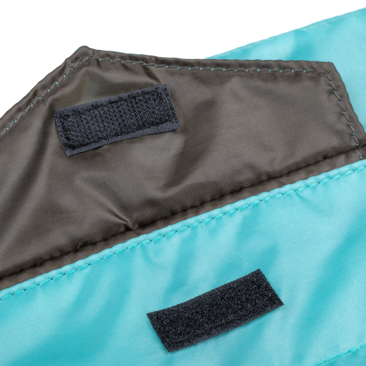 Blue puffer tablet case with dark fabric patch tabs and stitched edge detail