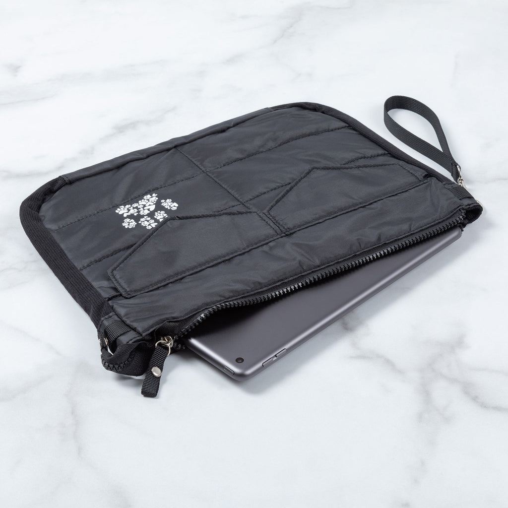 Black puffer tablet carrying case lying flat with zipper and paw print emblem