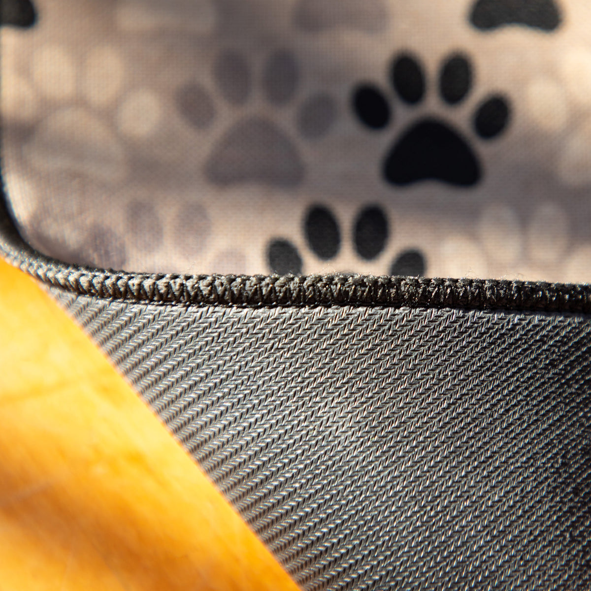 Tan floor runner edge with black paw prints and dark textured border