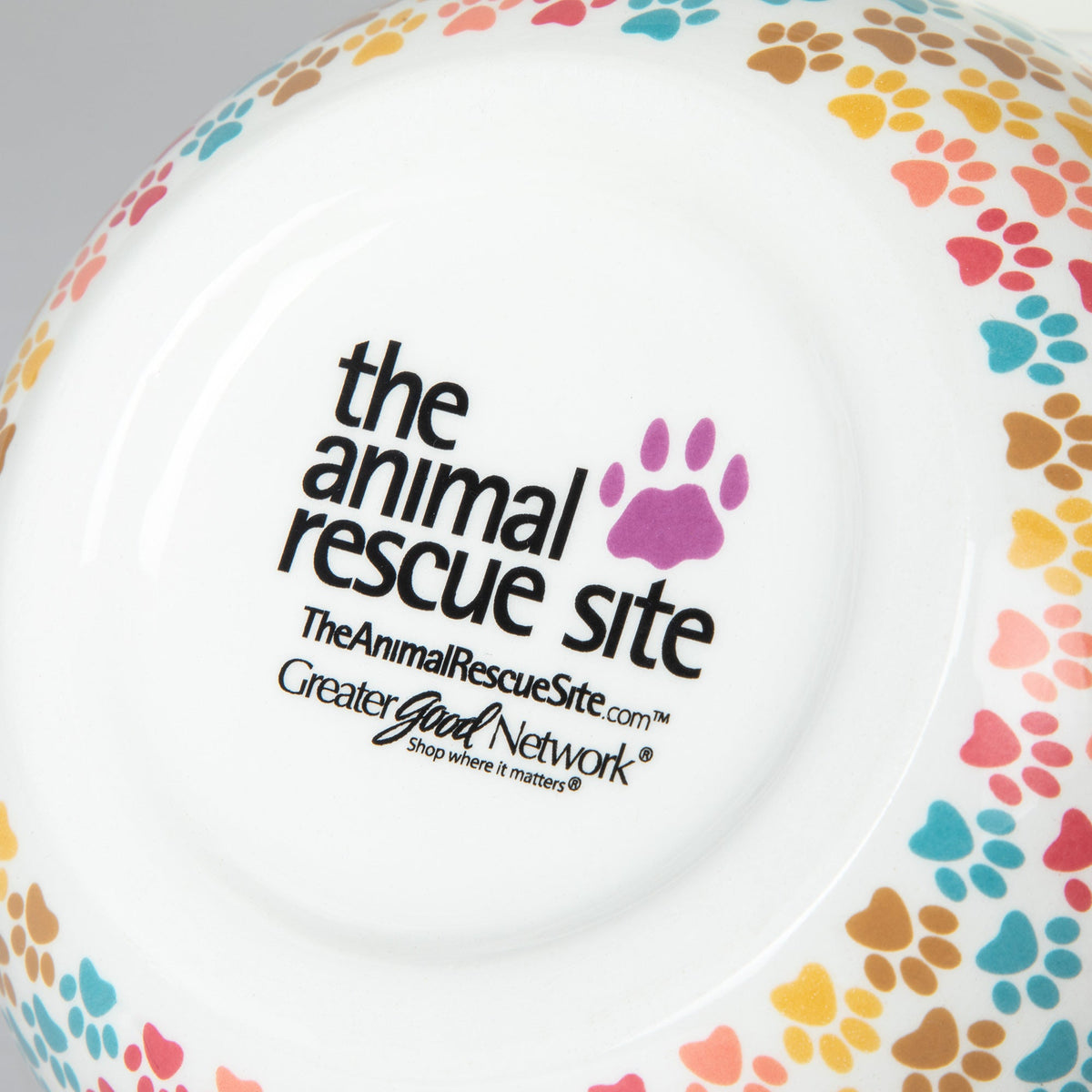 Close-up of ceramic paw-print bowl interior with colorful paw-pattern border