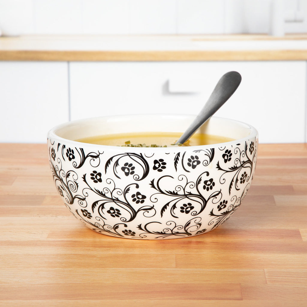 Ceramic black-and-white swirl paw bowl with spoon and food, white interior