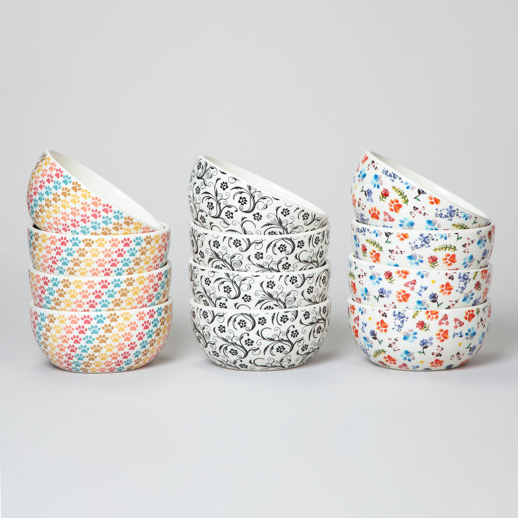 Set of 4 ceramic paw bowls with pastel multicolor paw-print and black swirl designs