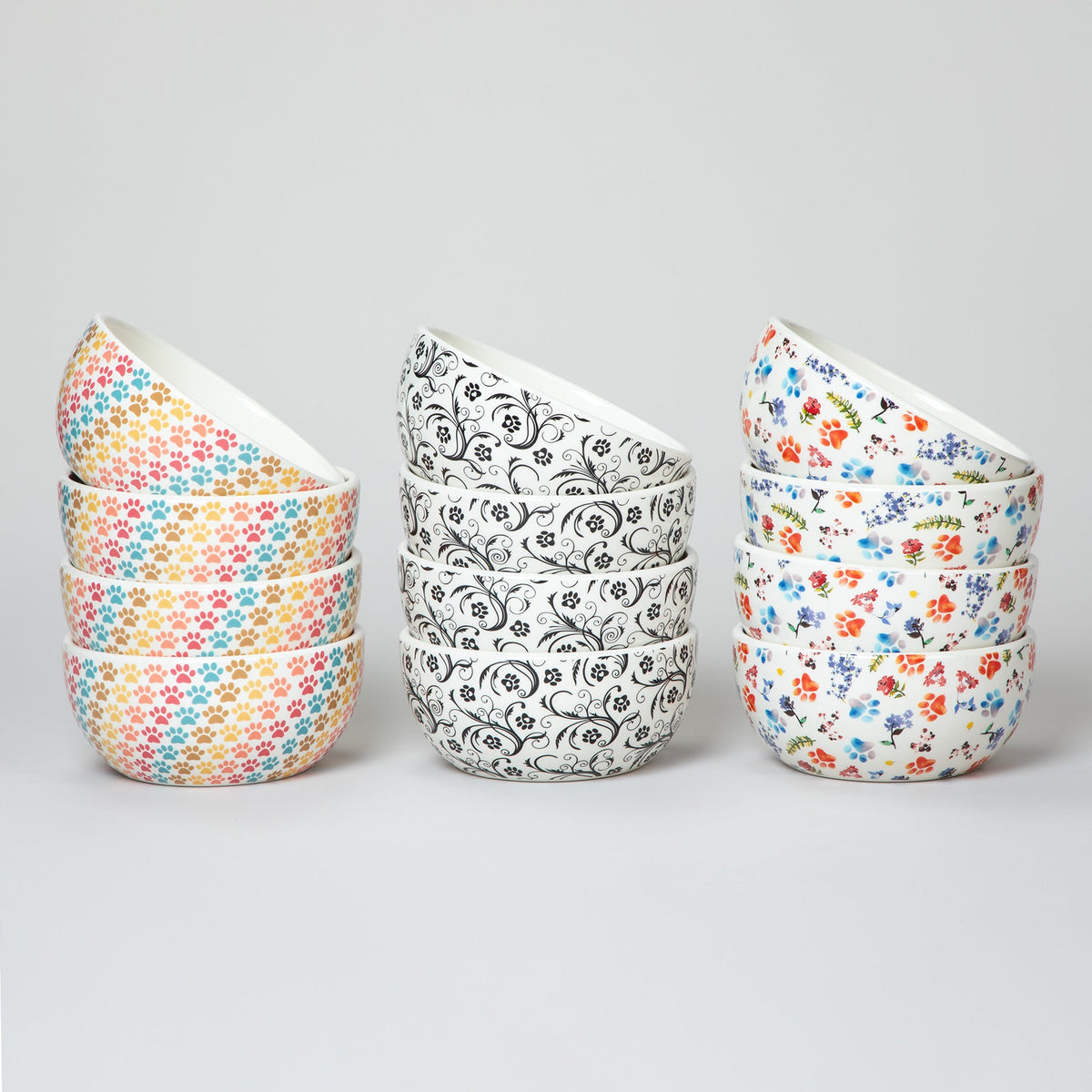 Set of 4 ceramic paw bowls with pastel multicolor paw-print and black swirl designs