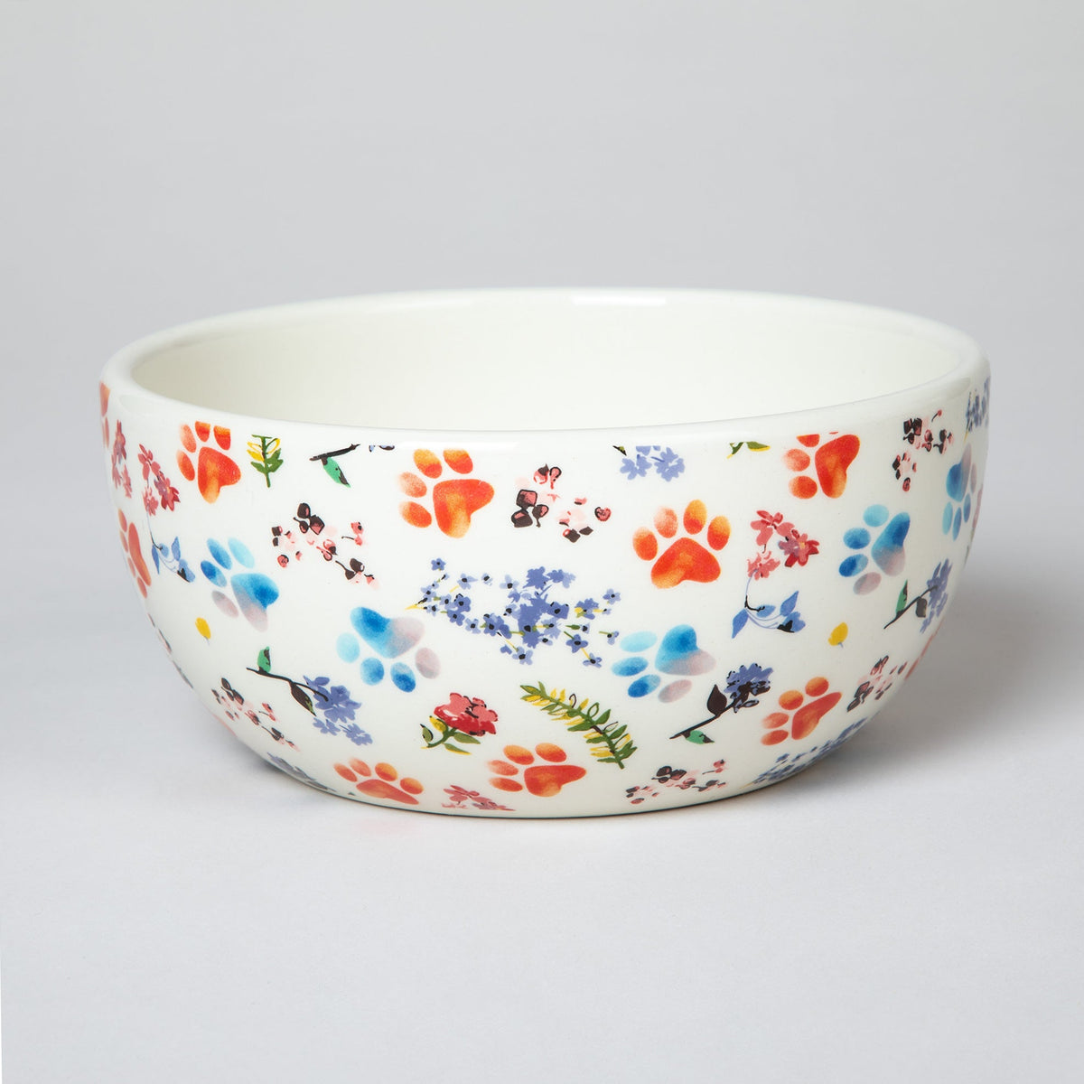Ceramic soup bowl with white base and multicolor paw-print and flower pattern