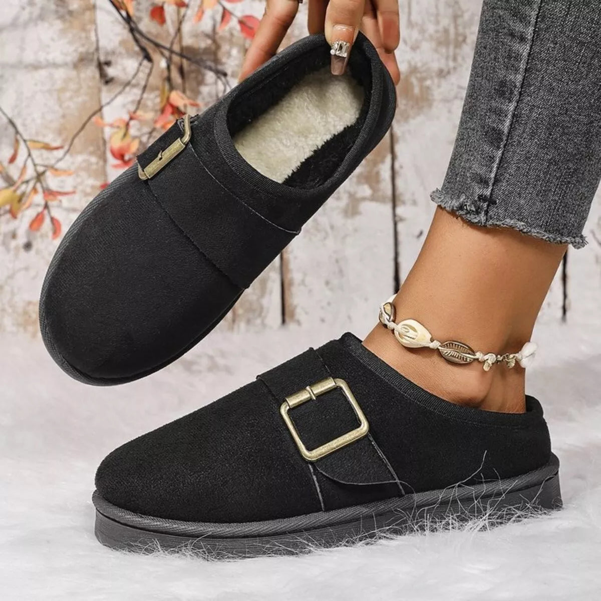 Black plush-lined slippers with open-top interior and gold-tone buckle strap