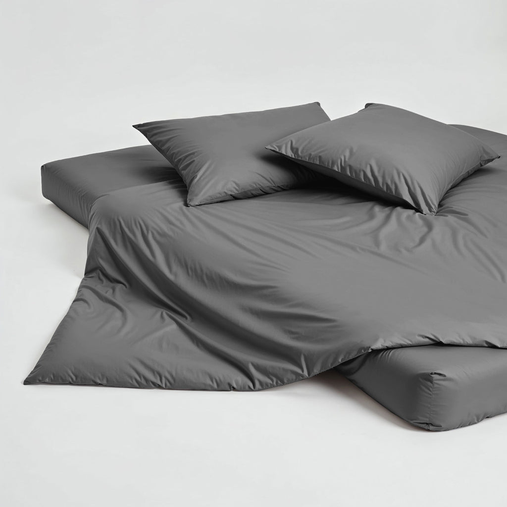 Gray sateen duvet cover and pillow shams neatly arranged on a flat surface
