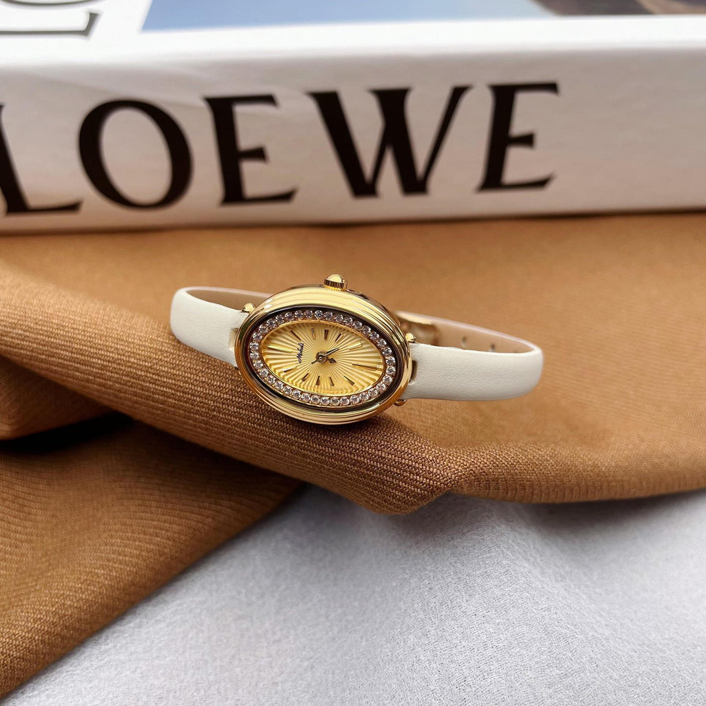 Ladies watch with gold bezel, yellow dial, white silicone strap.