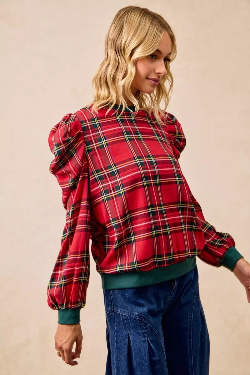 Red plaid puff-sleeve top with exaggerated shoulders and green hem and cuff details