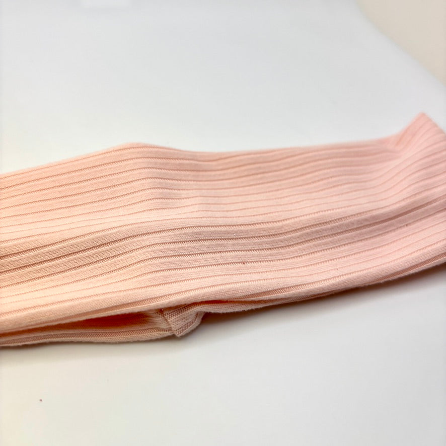 Light pink ribbed headband close-up with stitched fold detail
