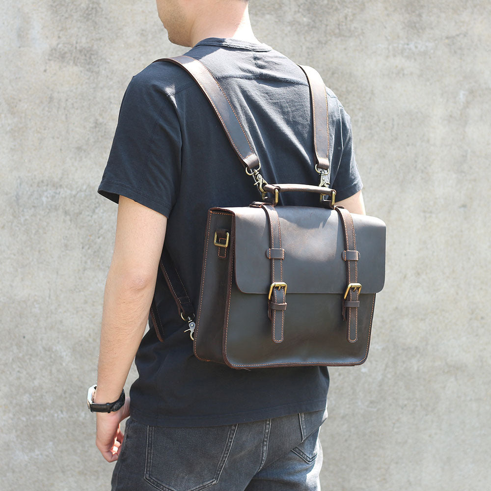 Brown leather messenger bag on back with shoulder strap and front flap buckle details