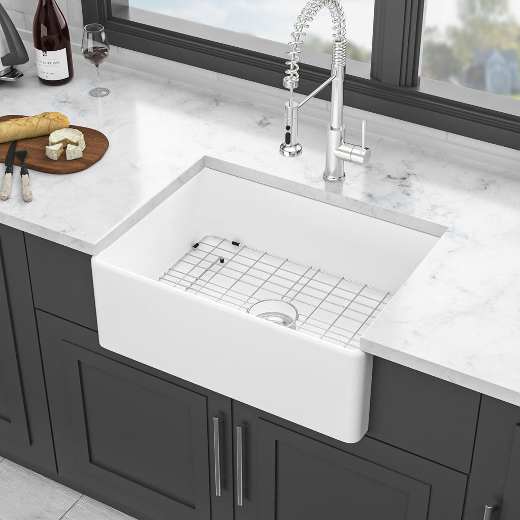White farmhouse apron-front single-bowl ceramic sink with bottom grid and center drain