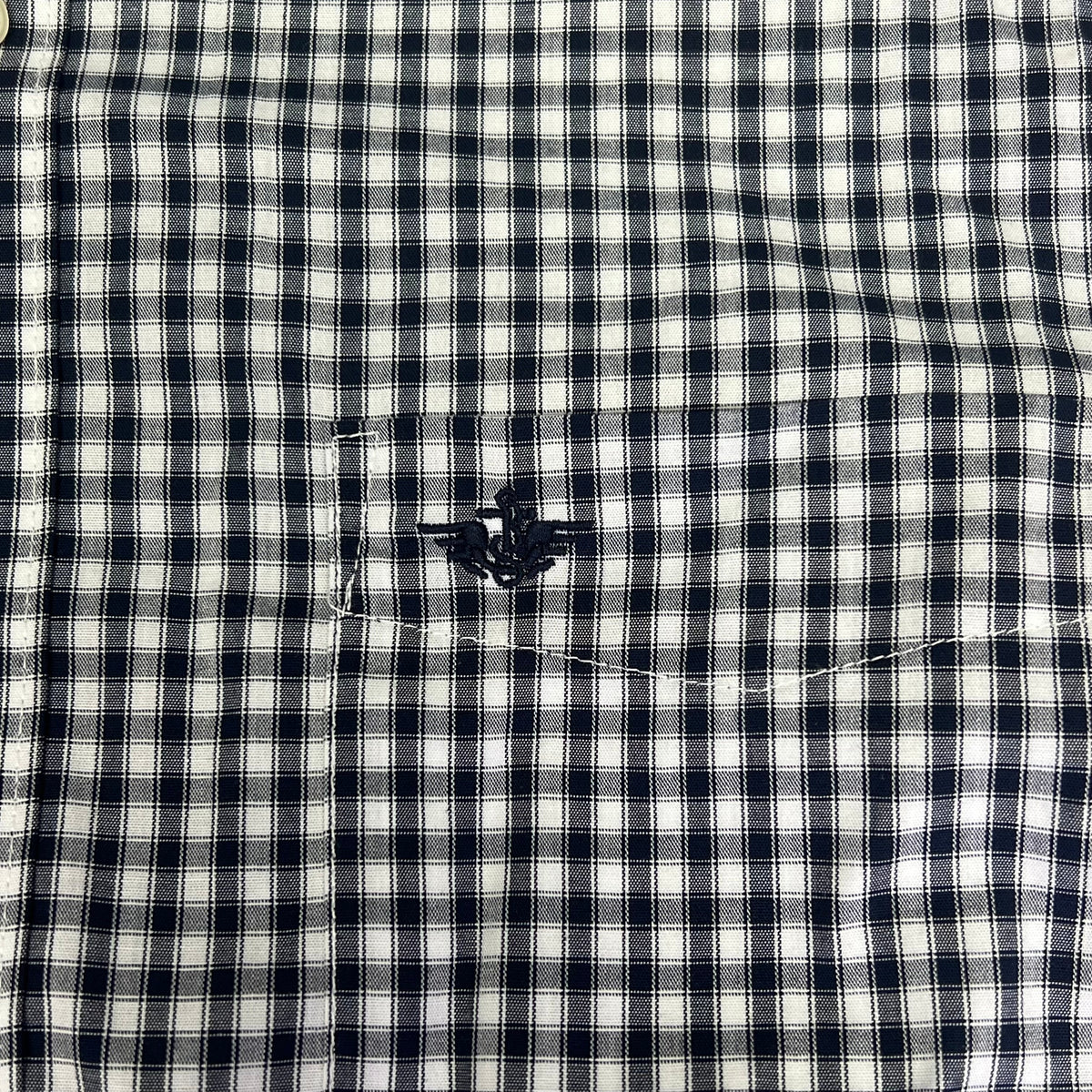 Men's plaid button-up shirt chest pocket detail with stitched flap and navy button, navy and white check