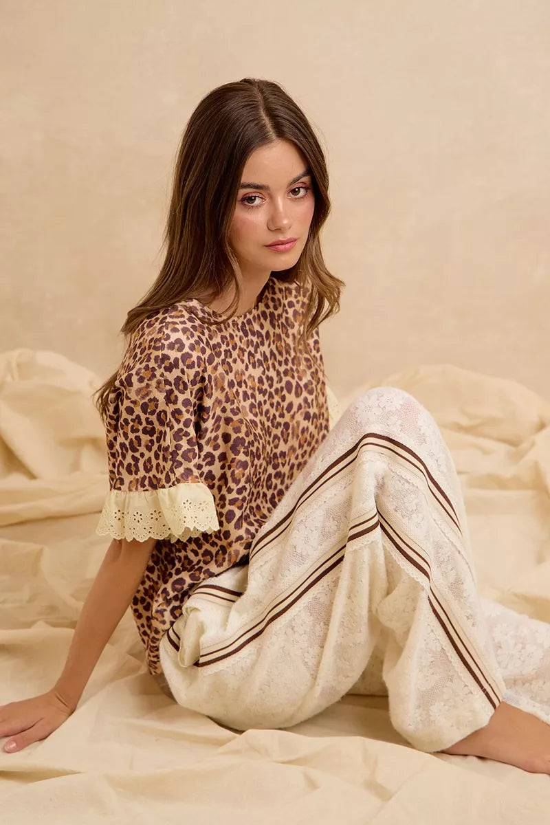 Leopard print ruffled top and shorts set with eyelet lace trim, reclining pose