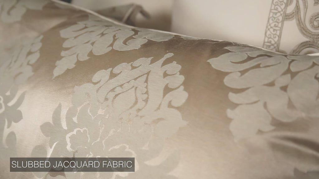 Ivory slubbed jacquard fabric close-up with ornate damask scroll motif