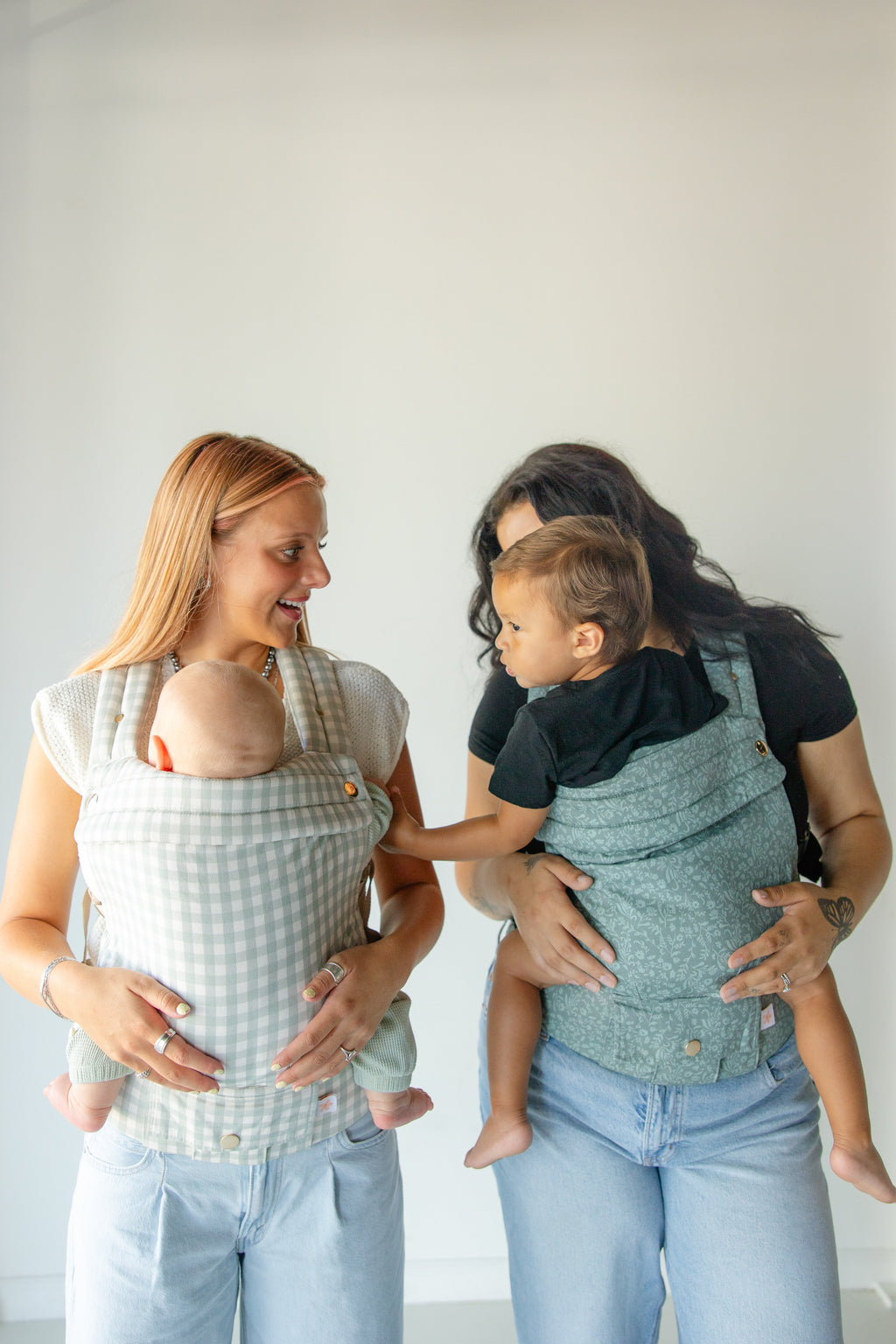 Teal floral baby carrier with pocket, parent carrying a toddler