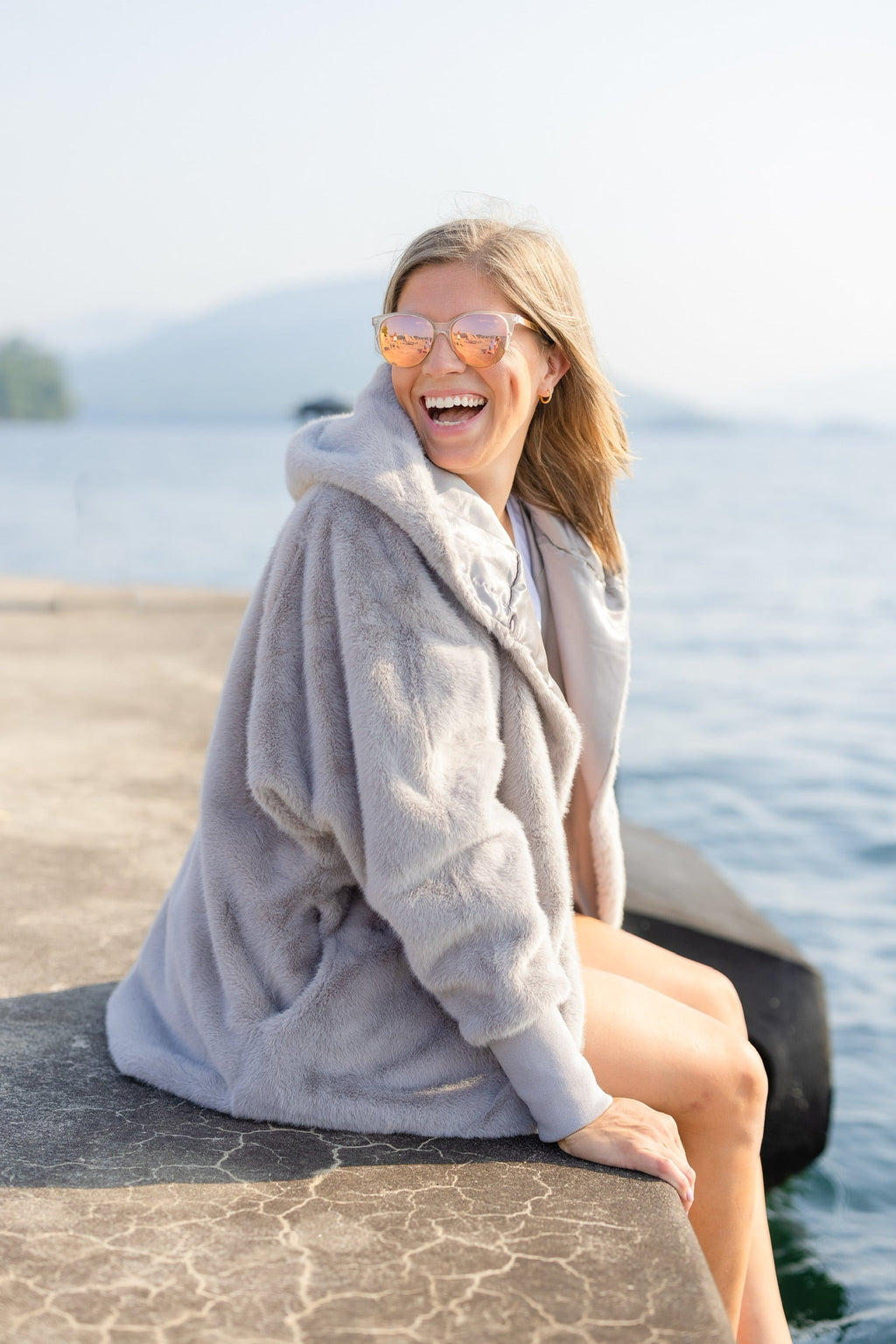 Grey zip-up waterproof cardigan with oversized hood and soft faux-fur texture