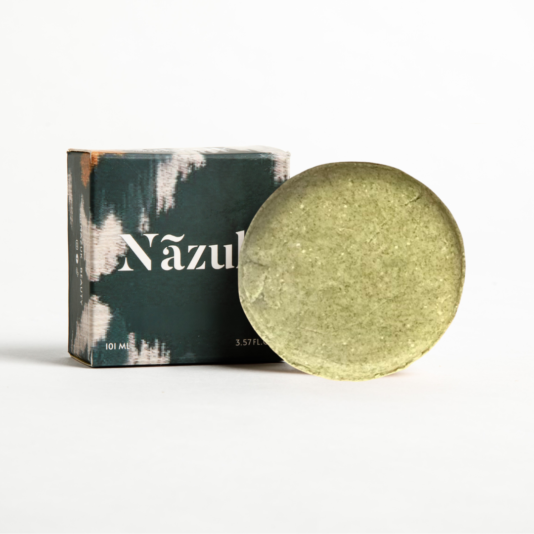 Green shampoo bar in a round shape with a cardboard box behind it