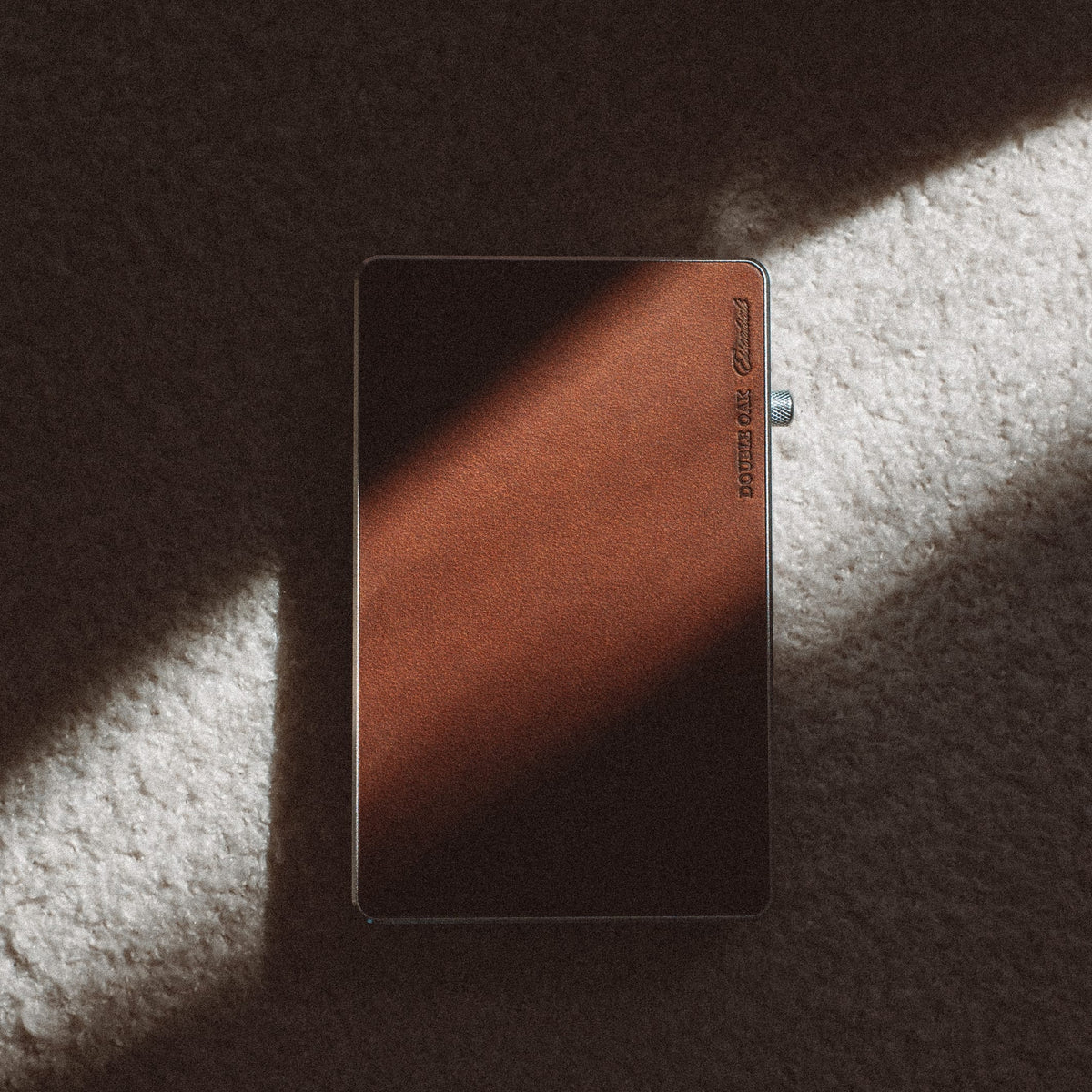 Brown leather cardholder wallet with metal edging, leather front panel, flat lay