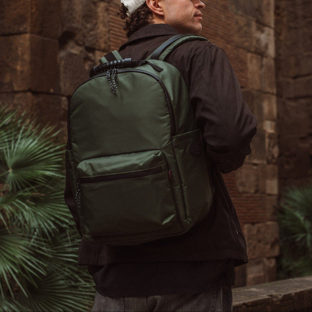 Green backpack with front pocket, adjustable shoulder straps, and chain zipper pulls.