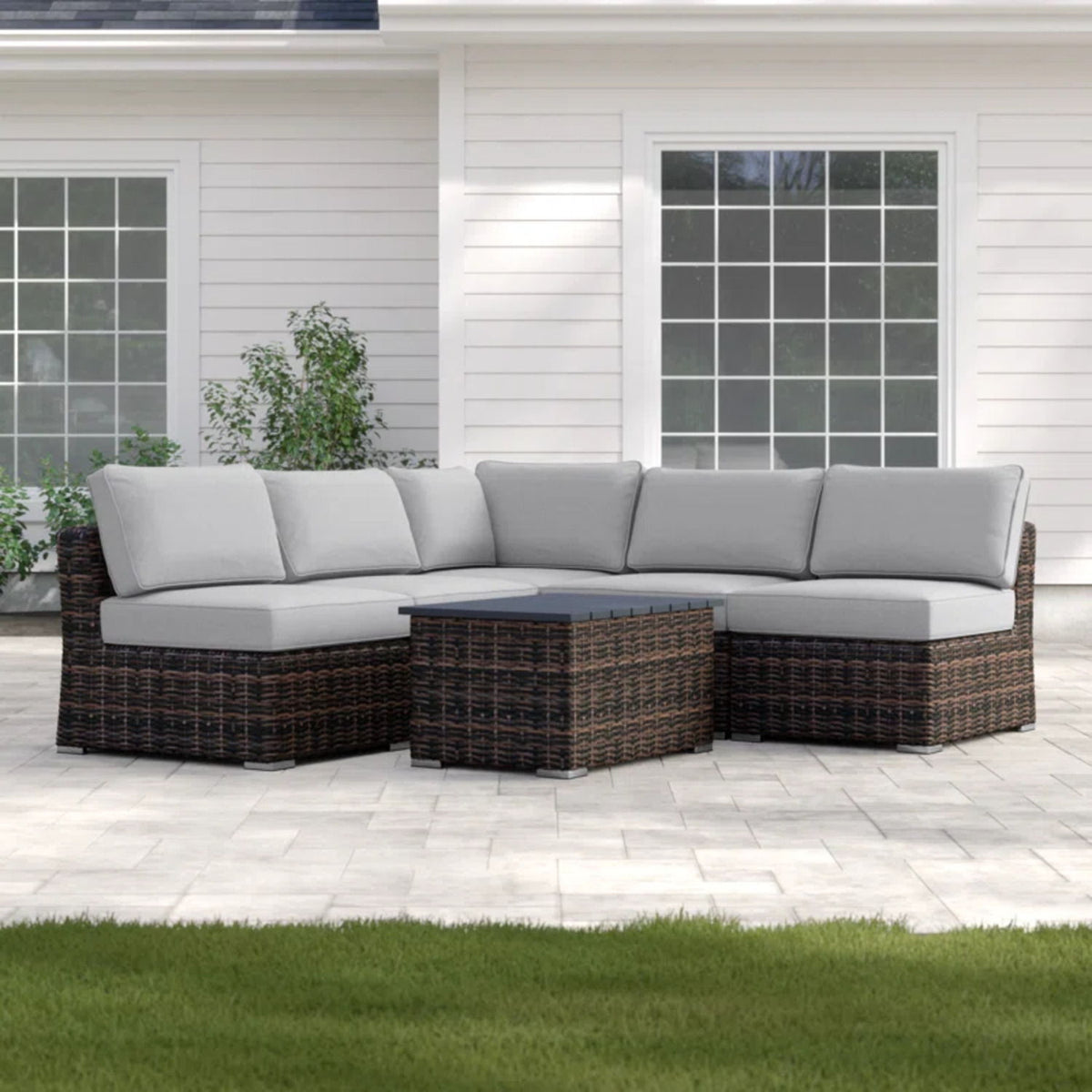 Dark wicker sectional sofa with light gray cushions and center storage table