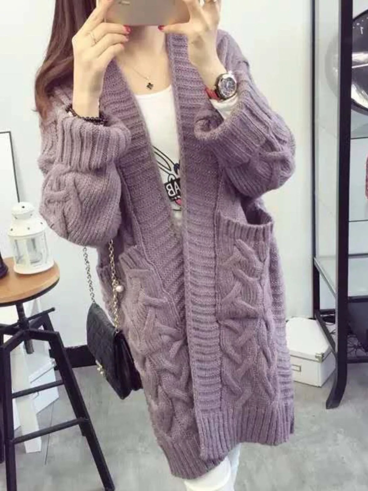 Lilac-purple long knit cardigan with open front, cable details, and chunky sleeves
