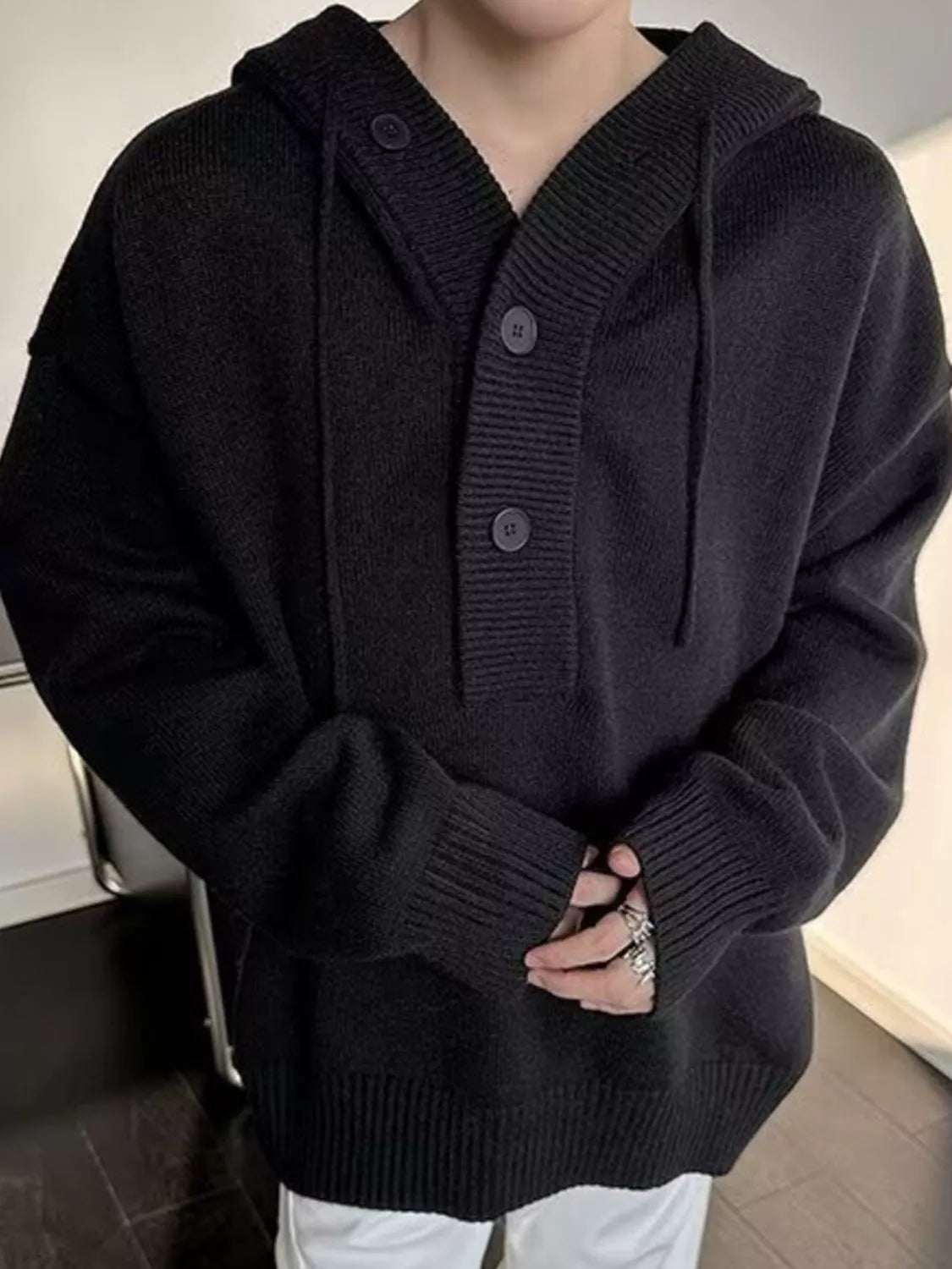 Black hooded knit sweater with button placket and front kangaroo pocket