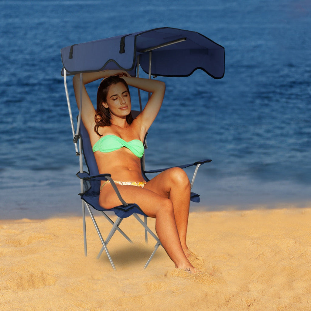 Foldable canopy beach chair with dark navy sunshade and padded seat on the beach