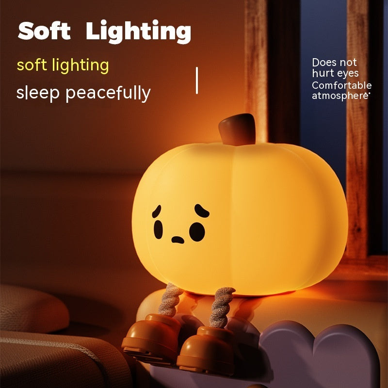 Soft silicone pumpkin lamp with sad face, warm bedside glow near furniture