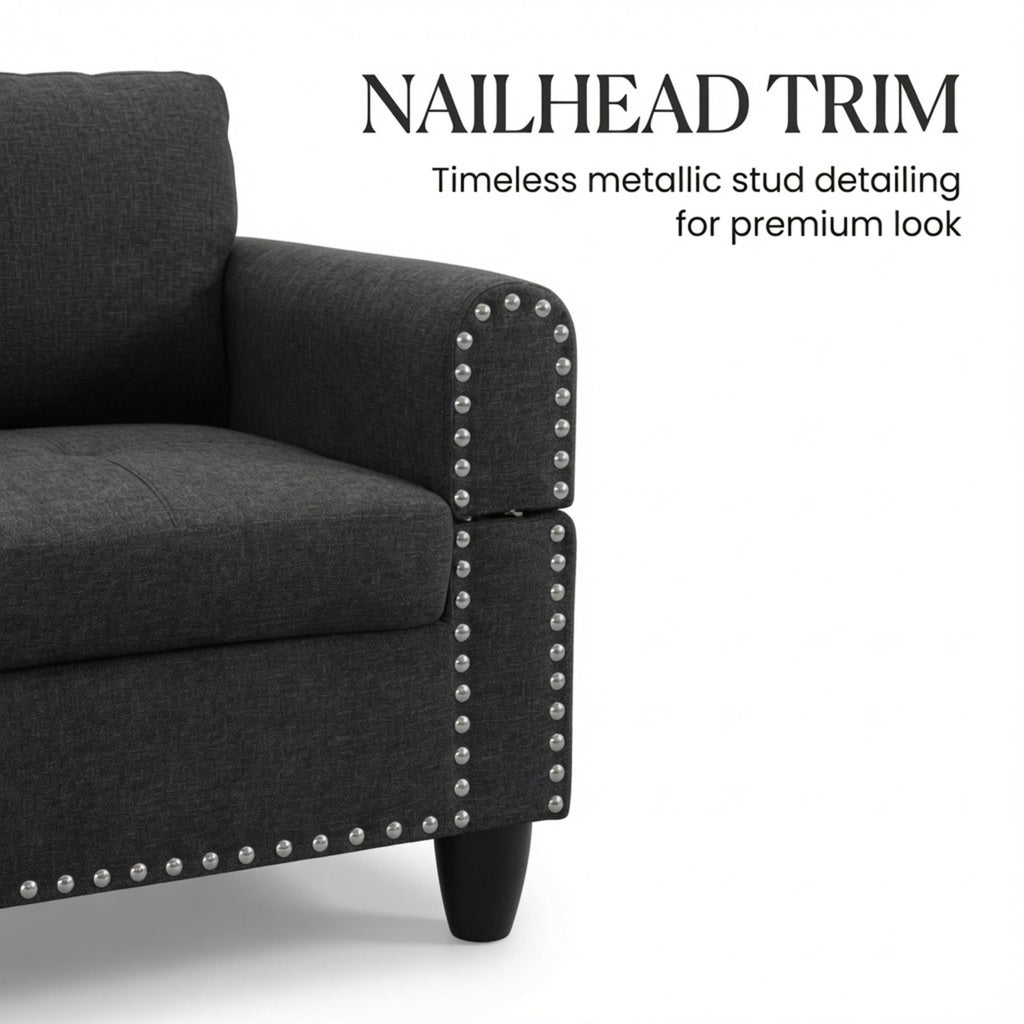Sectional sofa arm corner with metallic stud nailhead trim on a dark gray fabric seat